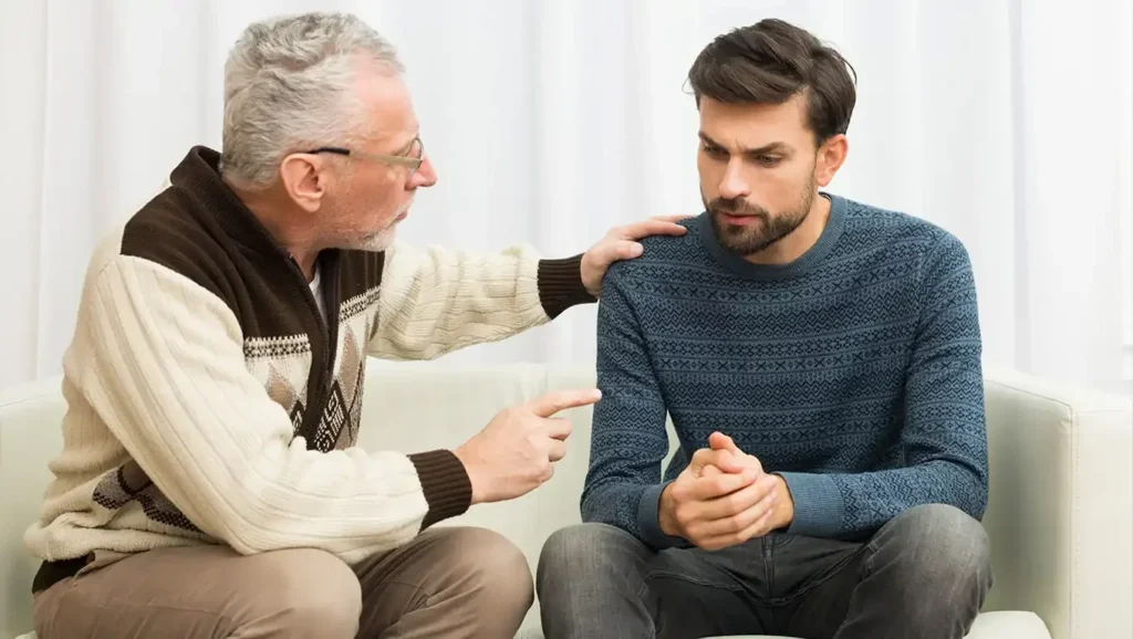 An older father offers his adult son comfort and advice during a difficult conversation.