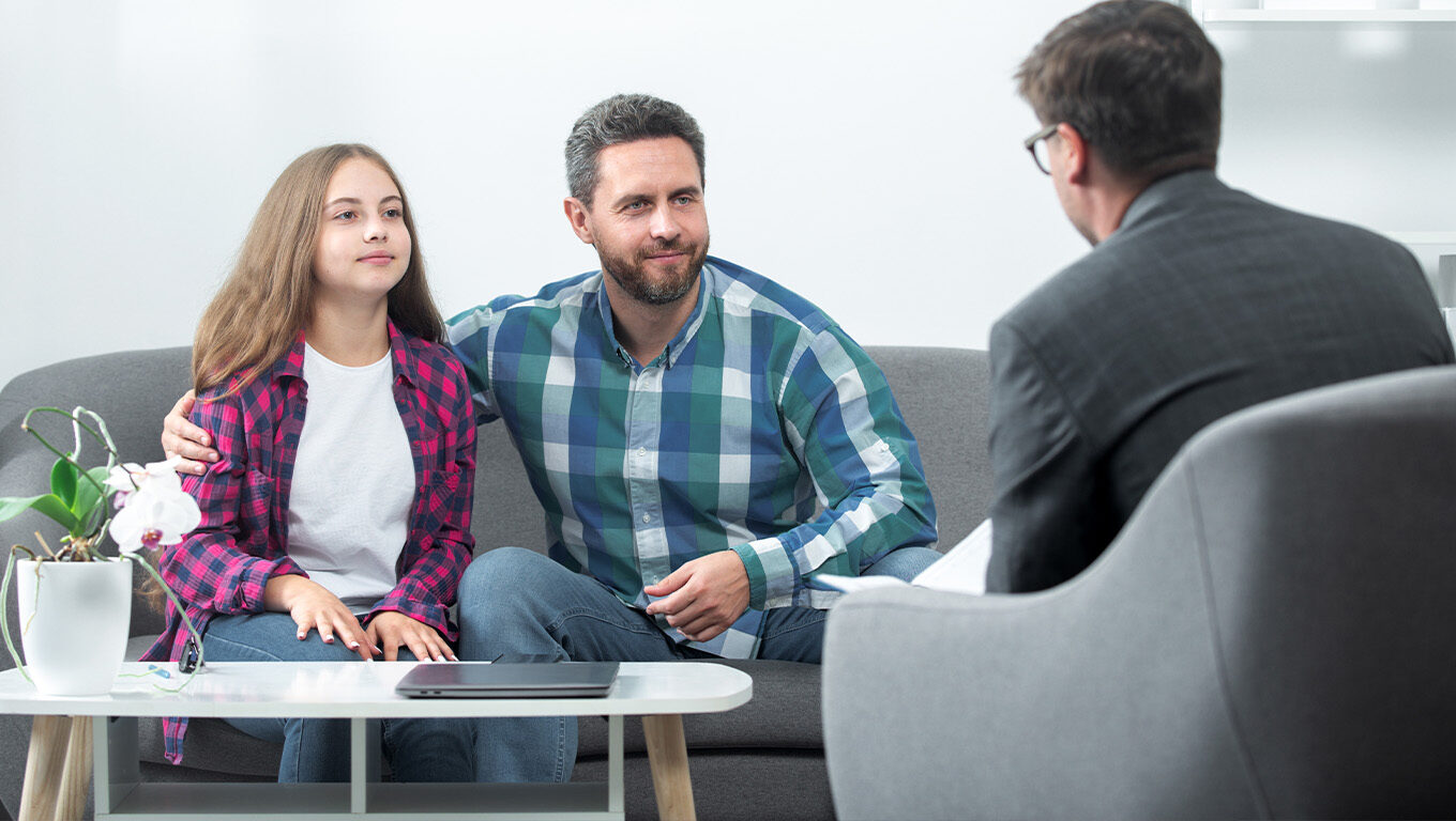 Father and daughter attending a family therapy session with a counselor.